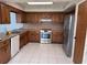 A well lit kitchen features stainless steel appliances, decorative wall paper, and plenty of storage at 460 Pinehurst Ct, Winter Haven, FL 33884