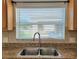 Close up of a kitchen sink with a large window and white blinds at 4610 Yellow Bay Dr, Kissimmee, FL 34758