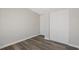 Bright bedroom with updated gray wood-look floors and a double door closet at 4957 Old Lucerne Park Rd, Winter Haven, FL 33881