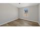 Cozy bedroom with a window view and modern gray wood-look flooring at 4957 Old Lucerne Park Rd, Winter Haven, FL 33881