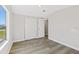 Bright bedroom featuring wood-look floors, a large window, and a closet at 4957 Old Lucerne Park Rd, Winter Haven, FL 33881