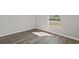 Bright bedroom featuring gray wood-look floors and a window with a view of the neighborhood at 4957 Old Lucerne Park Rd, Winter Haven, FL 33881