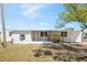 Charming white mobile home featuring a covered porch and well-maintained front yard at 4957 Old Lucerne Park Rd, Winter Haven, FL 33881