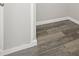 Corner of room with gray wood-look flooring and white trim, adding a modern touch at 4957 Old Lucerne Park Rd, Winter Haven, FL 33881