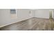 Bright living room featuring modern gray wood-look flooring, neutral walls, and natural light from the windows at 4957 Old Lucerne Park Rd, Winter Haven, FL 33881