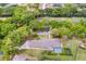 Overhead view showcasing a home with a screened pool, large yard, and mature trees in a residential neighborhood at 5020 Broadmore Dr, Auburndale, FL 33823
