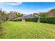 Expansive backyard featuring tall, verdant hedges and mature trees, offering privacy and tranquility at 5020 Broadmore Dr, Auburndale, FL 33823