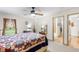 Comfortable main bedroom features a window, ceiling fan, access to the main bathroom, and a cozy bed at 5020 Broadmore Dr, Auburndale, FL 33823