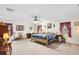 Spacious main bedroom with ceiling fan, windows providing natural light, and a comfortable king-size bed at 5020 Broadmore Dr, Auburndale, FL 33823