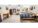 Spacious main bedroom with a ceiling fan, carpeted floor, and a blue and white quilt at 5020 Broadmore Dr, Auburndale, FL 33823