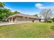 This home has an attached garage with ample parking space, complemented by a lush green lawn at 5020 Broadmore Dr, Auburndale, FL 33823