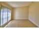 Bright, minimalist bedroom with tiled floors, a large window, and vertical blinds, showcasing natural light at 509 Heather Glen Dr, Winter Haven, FL 33884