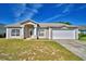 Charming single-story home featuring a two-car garage and well-maintained front yard under a bright blue sky at 509 Heather Glen Dr, Winter Haven, FL 33884