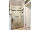 Bathroom shower featuring glass door, grab bar, shower seat and decorative tile at 579 Saint Andrews Rd, Winter Haven, FL 33884