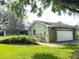 Home exterior features green siding, trimmed landscaping, and a brick walkway leading to the home at 579 Saint Andrews Rd, Winter Haven, FL 33884