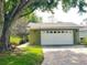 A single-car garage with a brick driveway, green siding, and white garage door is featured in this exterior shot at 579 Saint Andrews Rd, Winter Haven, FL 33884