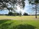 Green golf course with mature trees and blue sky, creating a scenic view at 579 Saint Andrews Rd, Winter Haven, FL 33884