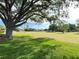 Expansive green golf course with mature trees and blue sky at 579 Saint Andrews Rd, Winter Haven, FL 33884
