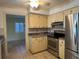 Kitchen with stainless steel appliances, two-tone cabinets, and a view into the dining room at 579 Saint Andrews Rd, Winter Haven, FL 33884