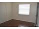 Hardwood-floored bedroom with white walls and one window with white blinds at 614 Chatham Dr, Lakeland, FL 33803