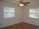 Bright bedroom featuring hardwood floors, a ceiling fan, and two windows with white blinds at 614 Chatham Dr, Lakeland, FL 33803