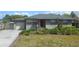 Charming single-story home with a well-maintained lawn, complemented by a one car garage and a red front door at 614 Chatham Dr, Lakeland, FL 33803
