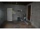 Concrete garage with a water heater, white shelves and a white door on the left at 614 Chatham Dr, Lakeland, FL 33803