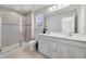 Well-lit bathroom with double vanity, a glass-enclosed shower, and modern finishes at 6237 Aralia Ivy Ln, Winter Garden, FL 34787