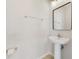 Modern half bathroom with a pedestal sink, framed mirror, and a chrome towel rack at 6237 Aralia Ivy Ln, Winter Garden, FL 34787