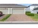 Exterior view of a two-car garage with a brick-paved driveway at 6237 Aralia Ivy Ln, Winter Garden, FL 34787
