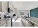 Spacious kitchen features granite countertops, a center island, stainless steel appliances, and a tiled backsplash at 6237 Aralia Ivy Ln, Winter Garden, FL 34787