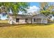 Charming single-story home with a white exterior, well-manicured lawn, and classic architectural details at 6430 Russo Rd, Bartow, FL 33830