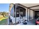 Exterior showcasing a screened front porch, white railings, and a convenient carport at 6450 Hollyberry Ne Ln, Winter Haven, FL 33881