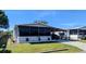 Charming home featuring a screened porch, carport, well-maintained lawn, and tasteful landscaping at 6450 Hollyberry Ne Ln, Winter Haven, FL 33881
