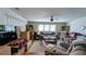 A comfortable living room with neutral colors, fan, bright windows, and a cozy sofa at 6450 Hollyberry Ne Ln, Winter Haven, FL 33881