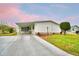 Inviting single-story home with a long driveway, carport, and manicured lawn at 6510 Oak Hammock Ln, Winter Haven, FL 33884