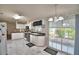 Bright kitchen featuring white cabinetry, black appliances, black countertop, and sliding glass doors at 6510 Oak Hammock Ln, Winter Haven, FL 33884