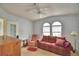 Living room with neutral carpeting, ceiling fan, arched windows, and traditional furnishings at 6510 Oak Hammock Ln, Winter Haven, FL 33884