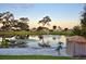 Pond with fountain, palm trees and several houses surrounding it at 6510 Oak Hammock Ln, Winter Haven, FL 33884