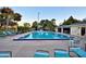 Community pool with plenty of lounge chairs and palm trees at sunset at 6510 Oak Hammock Ln, Winter Haven, FL 33884
