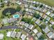 Aerial view showcasing a community with pool, pond, and neatly arranged homes in a scenic layout at 6603 Scenic Point Se Dr, Winter Haven, FL 33884