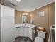 Bathroom showcasing a single sink vanity, ample cabinet space, and a toilet with an adjacent woven basket at 6603 Scenic Point Se Dr, Winter Haven, FL 33884