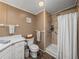 Full bathroom features a walk-in shower, a toilet with a decorative basket, and a white single sink vanity at 6603 Scenic Point Se Dr, Winter Haven, FL 33884