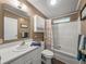 Cozy bathroom featuring a white vanity, matching cabinets, and a shower-tub combo with decorative curtain at 6603 Scenic Point Se Dr, Winter Haven, FL 33884