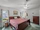This bedroom features a wood sleigh bed, ceiling fan, and an ensuite bathroom for added convenience and privacy at 6603 Scenic Point Se Dr, Winter Haven, FL 33884