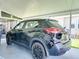 Carport featuring a black Nissan Kicks parked, offering convenient covered parking at 6603 Scenic Point Se Dr, Winter Haven, FL 33884