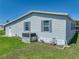 Charming home exterior with blue shutters, well-maintained lawn, and modern air conditioning unit at 6603 Scenic Point Se Dr, Winter Haven, FL 33884