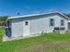 Back of a single-story home featuring vinyl siding, manicured lawn, and clear blue sky at 6603 Scenic Point Se Dr, Winter Haven, FL 33884