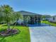 Charming single-story home showcasing a covered carport, lush lawn and tropical landscaping at 6603 Scenic Point Se Dr, Winter Haven, FL 33884