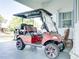 Golf cart parked in front of home featuring black and red seats and custom wheels at 6603 Scenic Point Se Dr, Winter Haven, FL 33884